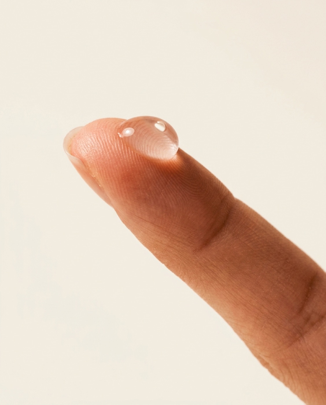 A pearl of the clear gel resting on a fingertip.